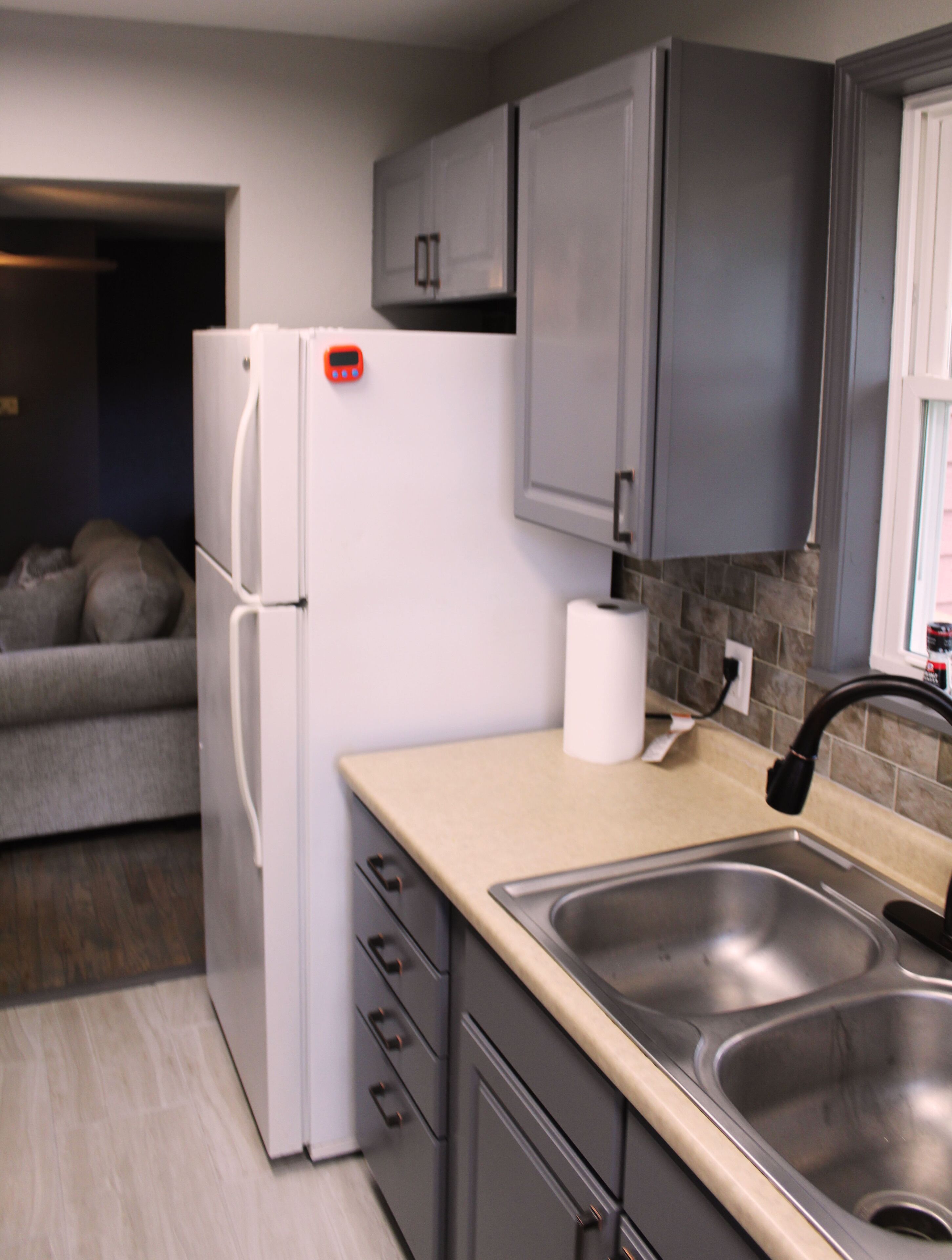 A modern kitchen with a refrigerator, a sink, and cabinets.