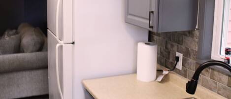 A modern kitchen with a refrigerator, a sink, and cabinets.