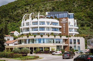 A hotel with a modern design, featuring multiple balconies and a restaurant on the ground floor.