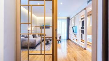 A modern living room with a wooden floor, a sofa, a coffee table, and a TV.