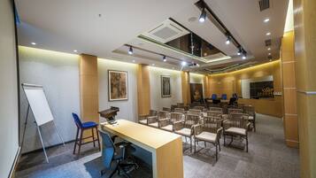 A conference room with a long table, chairs, a whiteboard, and a podium.