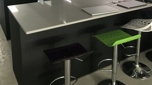 Une cuisine moderne dotée d’un îlot central, de tabourets de bar et d’un réfrigérateur.