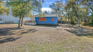A small blue house with a wooden deck and a fenced yard. - High Tide in Windy Hill (North Myrtle Beach)