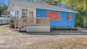 A single-story house with a blue exterior, a wooden deck, and a small porch. - High Tide in Windy Hill (North Myrtle Beach)