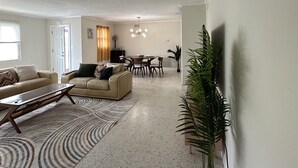 Un salón amplio con un conjunto de sofás, una mesa de centro y un comedor con sillas.