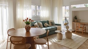 A modern living room with a green sofa, a round dining table with chairs, and a small coffee table. - Urban Athéna Apartment,Pangrati (Athina)