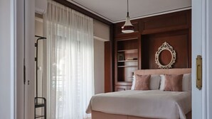 Une chambre à coucher avec un grand lit, une armoire, un miroir et une porte donnant sur une autre pièce.