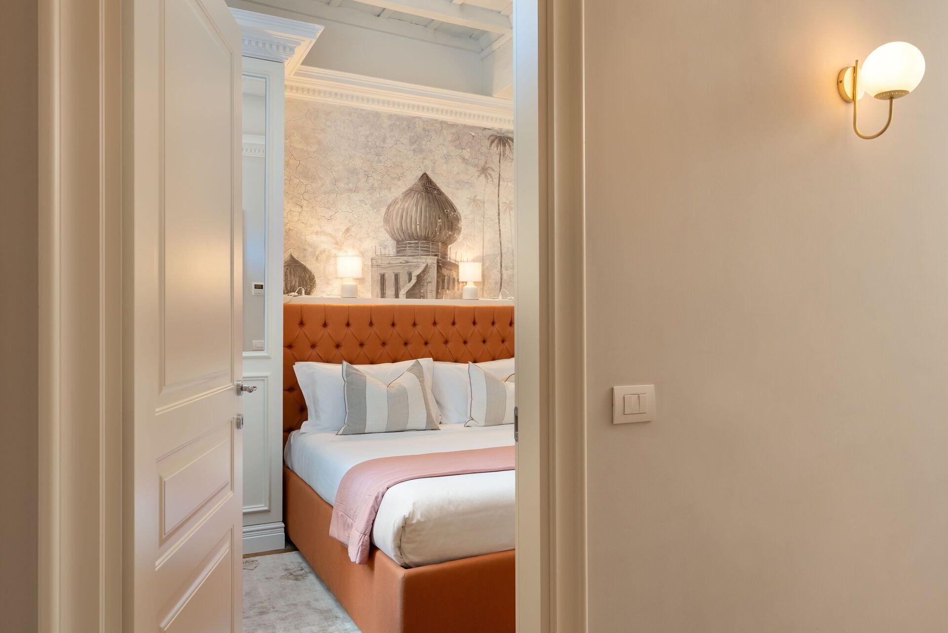 Una camera da letto con un letto grande, un muro decorativo e un punto luce a parete.