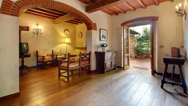 Una sala de estar acogedora con pisos de madera, una chimenea y un comedor con sillas y una mesa.