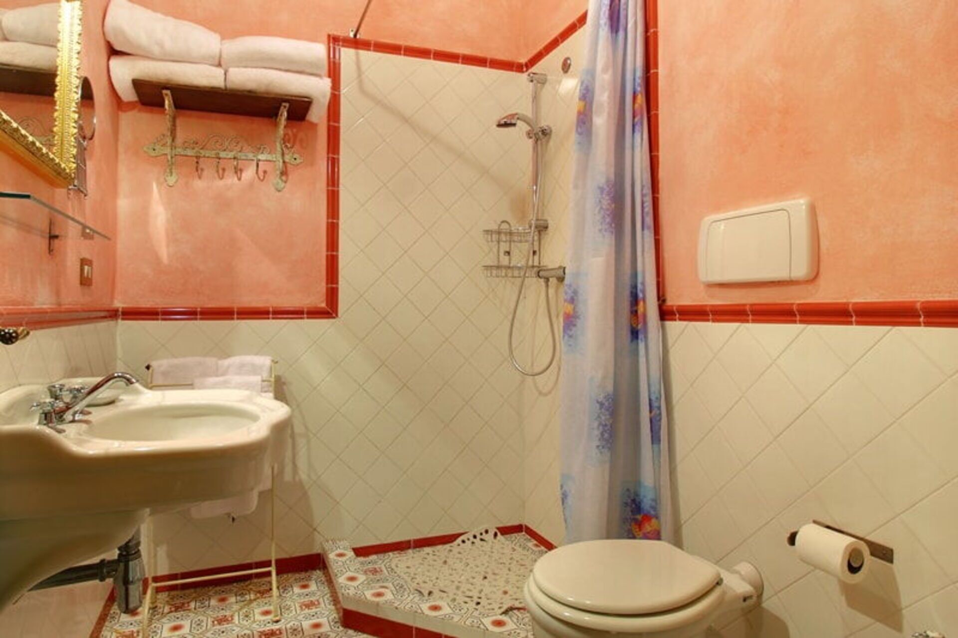 Ein Badezimmer mit Waschbecken, Toilette, Dusche und dekorativen Handtüchern.