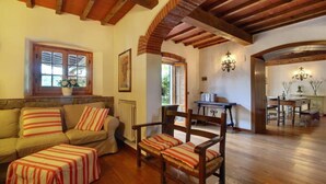 Una sala de estar acogedora con un sofá, sillones y piso de madera.