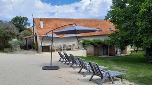 Un espace patio avec des sièges d’extérieur et une table abritée.