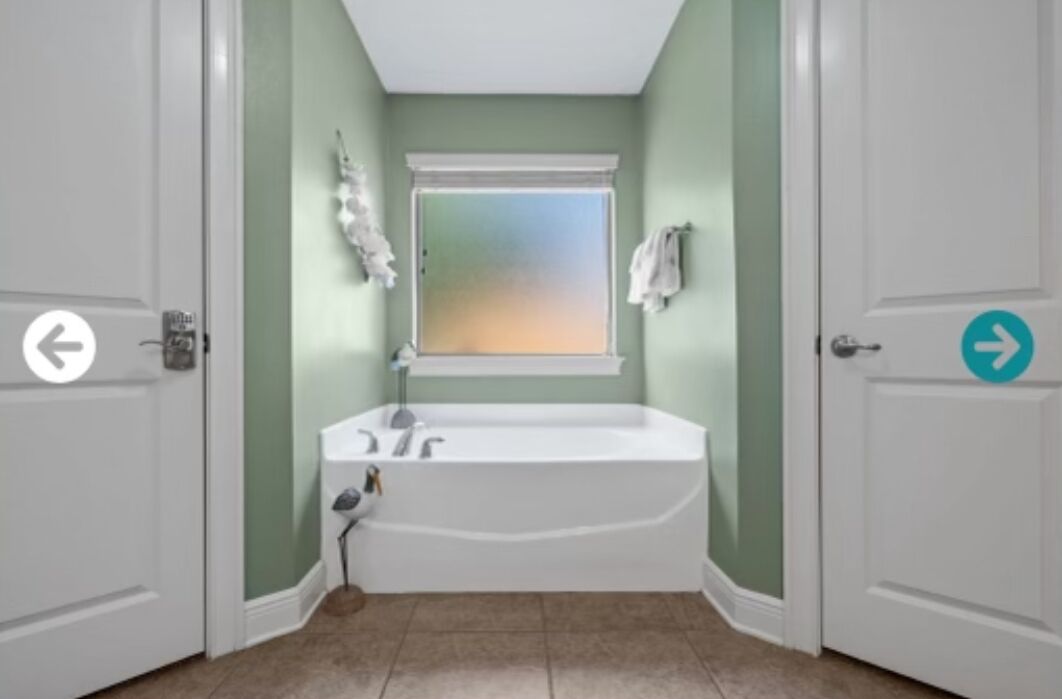 Un baño con una bañera independiente, una ventana y un perchero para toallas.