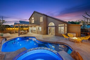 Ein Haus mit Schwimmbad, Sitzgelegenheiten im Freien und einer Terrasse.