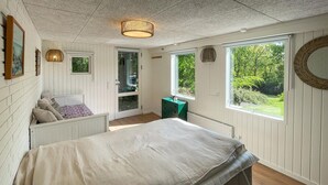 Um quarto com cama, janela, porta e luminária no teto.