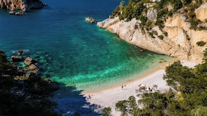 Yksityinen ranta, mustaa hiekkaa, aurinkotuoleja, aurinkovarjoja