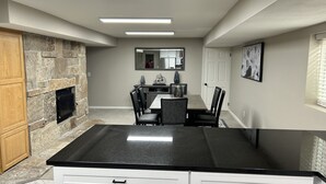A modern kitchen with a stone backsplash, a black countertop, and white cabinetry. - DEER CAVERN secluded 4 bedroom 2 bath house East Sandy base of Alta & Snowbird (Sandy)