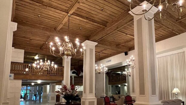 Eine großzügige Lobby mit hohen Decken, Kronleuchtern und einer zentralen Blumenkomposition.
