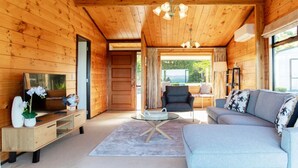 Un interior de madera con sofá, televisor y zona de comedor.