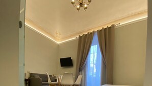 Un salon moderne avec un sol à motifs, un canapé, un téléviseur et un lit.