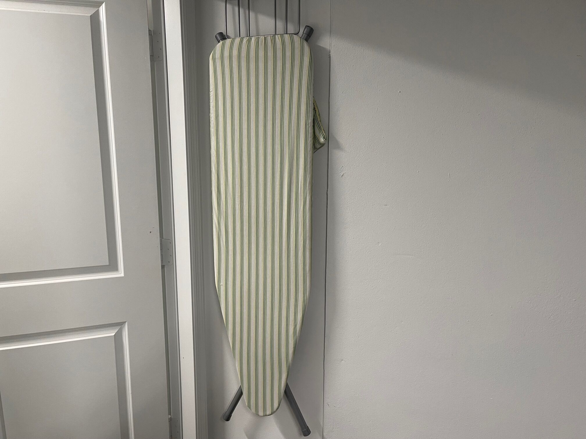 Ein gestreifter Bügelbrett hängt an der Wand.