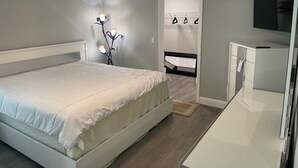 A bedroom with a bed, bedside table, wardrobe, and a ceiling fan. - New modern 3-bed 2 bath house with smart TV's in every room, WIFI, and hot tub (Fort Pierce)