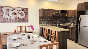 Una cocina moderna con armarios de madera oscura, un refrigerador de acero inoxidable y una encimera de granito.