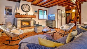 A cozy living room with a fireplace, comfortable seating, and a television.