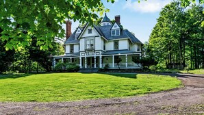 A large, two-story house with a wrap-around porch, surrounded by a well-maintained lawn and trees. - 5 bdrm Victorian, built in 1881-With 21 rooms, on a hill on 4 VERY private acres (New Windsor)