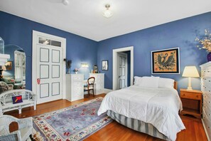 A bedroom with a large bed, a dresser, a desk, and a chair. There is a door and a window in the room. - 5 bdrm Victorian, built in 1881-With 21 rooms, on a hill on 4 VERY private acres (New Windsor)