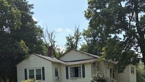 A two-story house with a front porch and a small front yard. - Cute cottage in a rural setting (Clemmons)