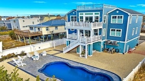 A two-story blue house with a swimming pool and outdoor seating. - Bay and Beach Views Sunsets! Elevator, Heated Saltwater Pool open May 23, 2026.
 (Beach Haven)