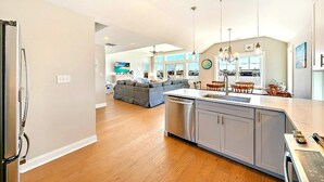 A spacious kitchen with a central island, wooden flooring, and modern appliances. - Bay and Beach Views Sunsets! Elevator, Heated Saltwater Pool open May 23, 2026.
 (Beach Haven)
