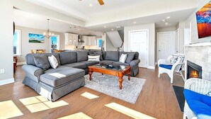 A spacious living room with a sectional sofa, a coffee table, and a fireplace. - Bay and Beach Views Sunsets! Elevator, Heated Saltwater Pool open May 23, 2026.
 (Beach Haven)