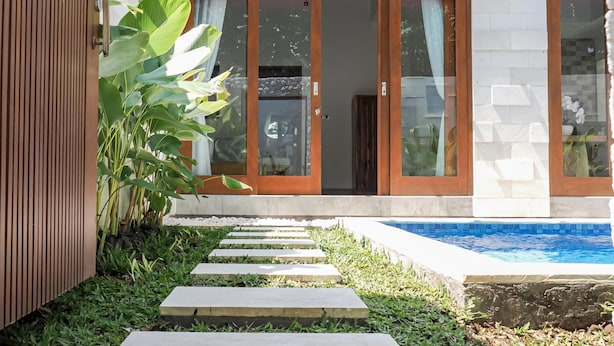 A modern house with a swimming pool, stone steps, and large green plants. - Belvilla Serene Haven Nusa Dua Beach (Nusa Dua)