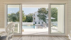 Habitación con puerta corrediza de vidrio que da a un área de piscina al aire libre.