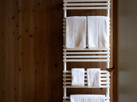 A wooden floor with a white towel rack holding two folded towels.
