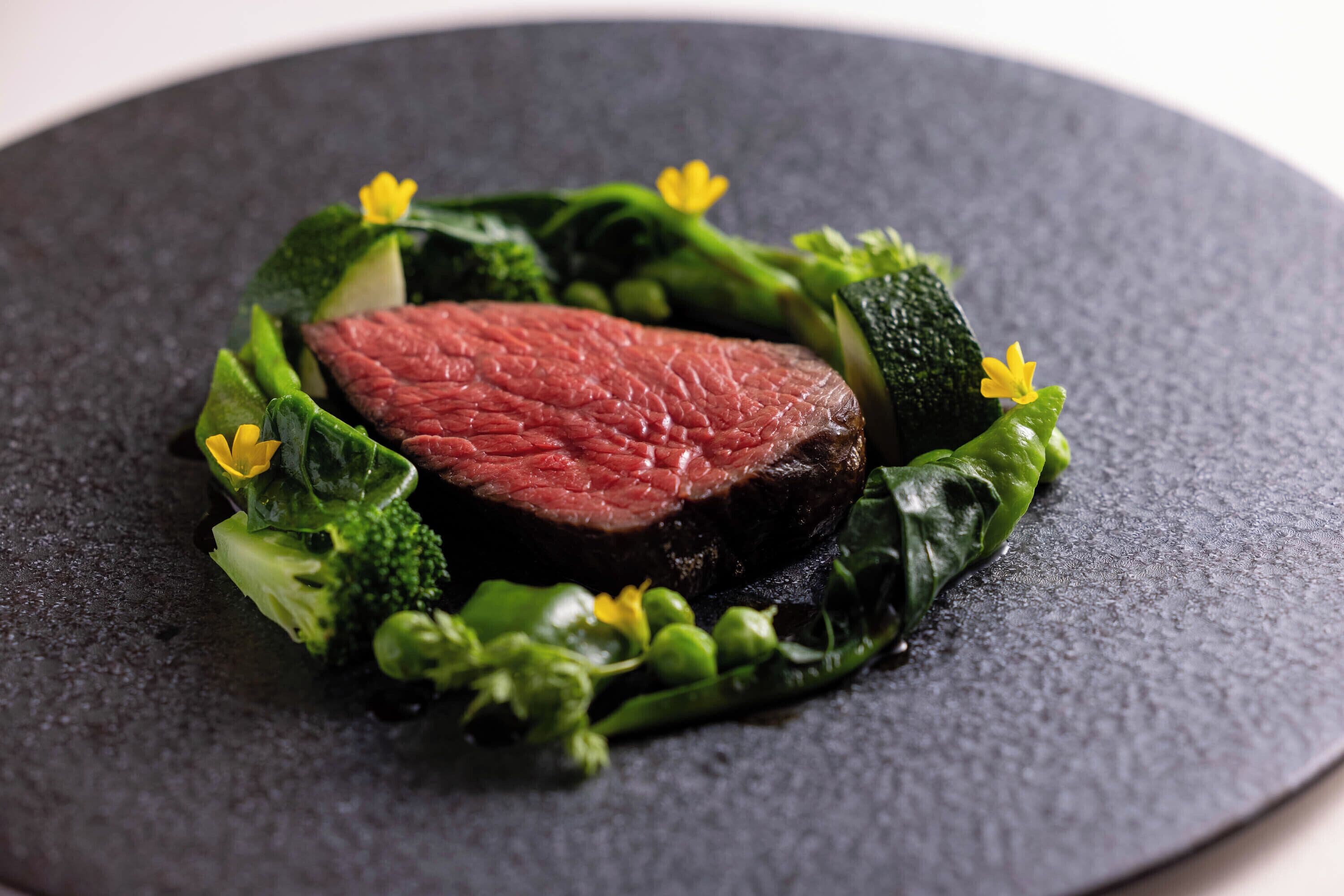A plate with a steak, broccoli, and zucchini.