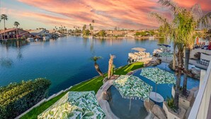 A waterfront resort with a swimming pool, palm trees, and a sunset view. - 5BR w lake view, heated pool, hot tub, sauna (Gilbert)