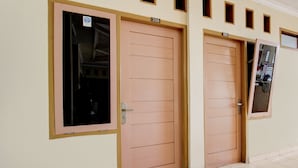 Une rangée de portes portant les numéros 208 et 209, indiquant un couloir d’hôtel dont le sol est recouvert de carreaux.