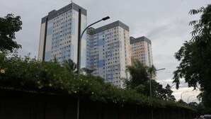 Ein Hochhaus mit mehreren Balkonen und einer Straßenlaterne davor.