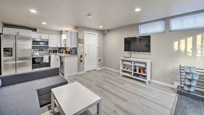 A modern kitchen with stainless steel appliances, a grey sofa, and a flat-screen TV. - Nicely remodeled 3 bed house in Seattle - Free parking (Seattle)
