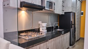 Une cuisine moderne équipée d’une cuisinière à gaz, d’une machine à café, d’un four à micro-ondes et d’un réfrigérateur.