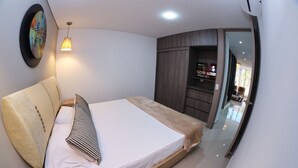 Une chambre à coucher moderne avec un grand lit, une armoire et un miroir.
