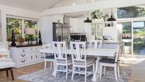 A modern kitchen with white cabinetry, a central island, and pendant lighting.