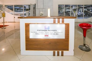 A reception desk with a sign for Fortune88 Property, including contact details and location.