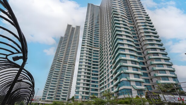 A high-rise building with a curved facade and multiple balconies. - Collection O Fortune 88 Kamala Lagoon Reception at Indomaret and White Forest (Bekasi)