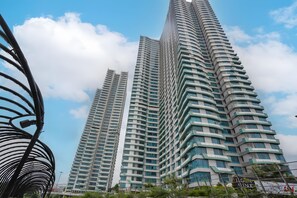 A high-rise building with a curved facade and multiple balconies. - Collection O Fortune 88 Kamala Lagoon Reception at Indomaret and White Forest (Bekasi)