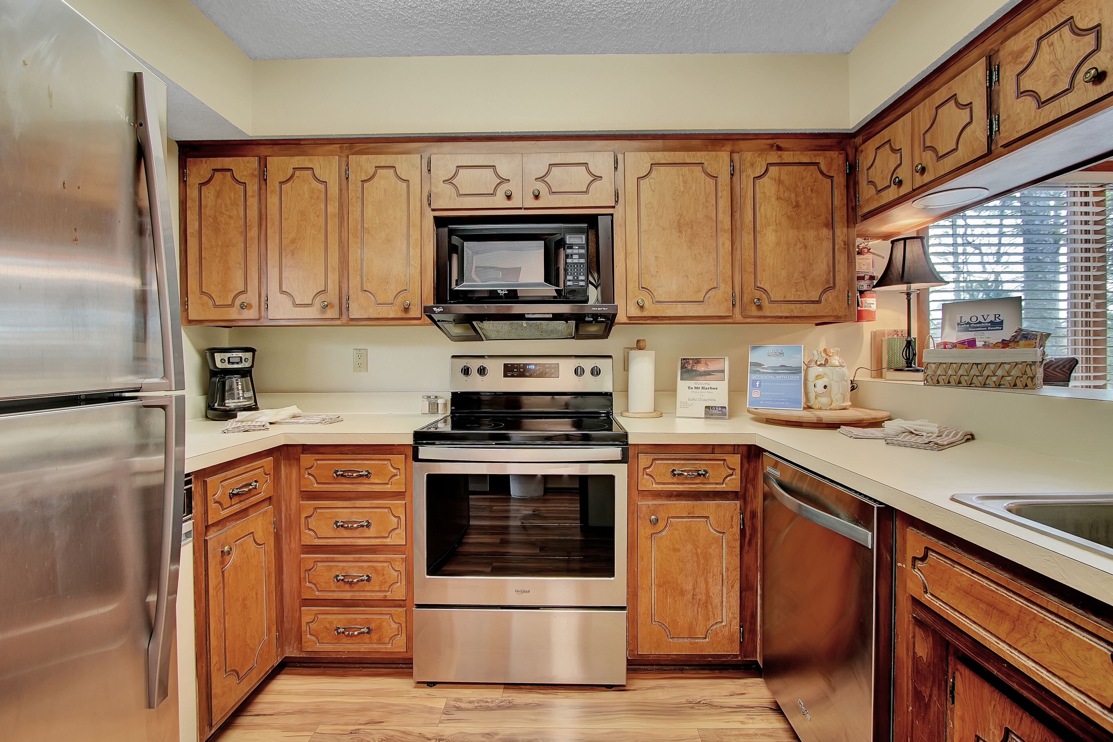 A kitchen with wooden cabinets, stainless steel appliances, and a built-in microwave.