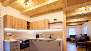 A modern kitchen with wooden cabinets, a built-in oven, and a sink. - Pod lesem by Interhome (Smržovka)
